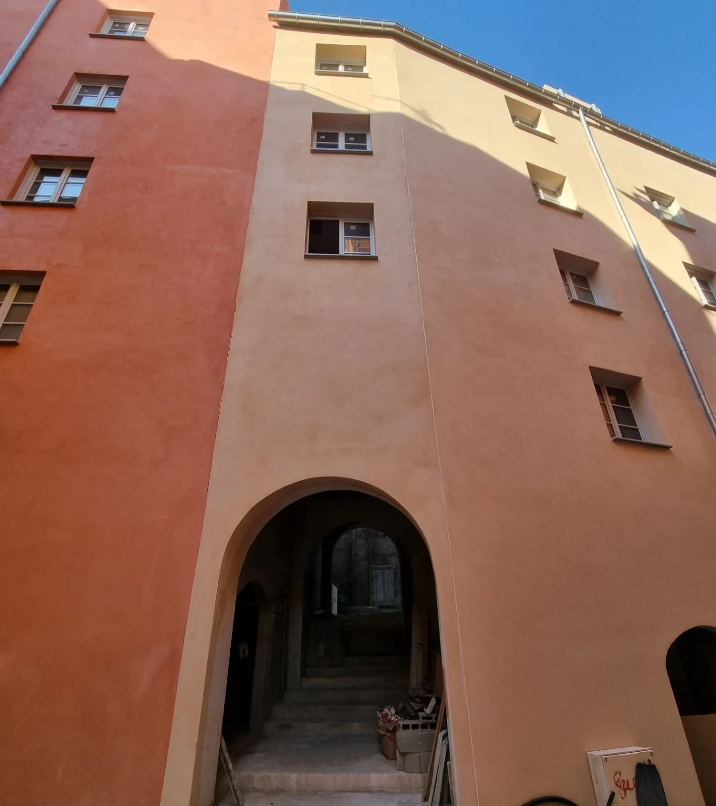 Façade d’un immeuble du centre-ville de Bastia, enduit rouge et ocre clair, porche en arc